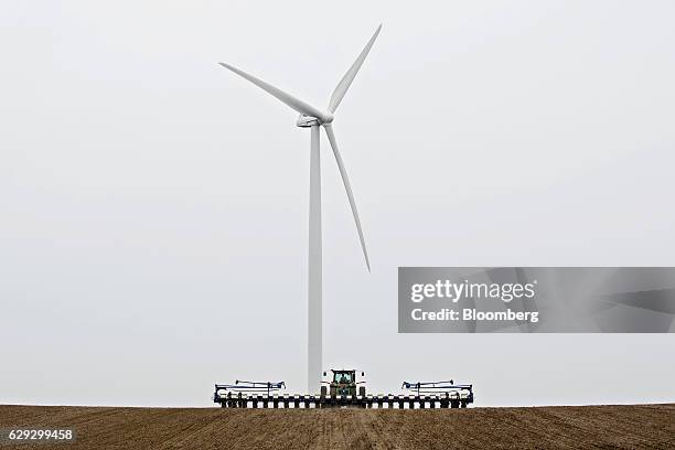 Bloomberg Best of the Year 2016: The Cresent Ridge wind farm, managed by Vestas Wind Systems A/S, stands as a John Deere & Co. Tractor pulls a Kinze...