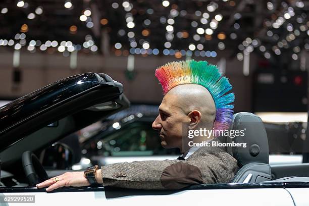 Bloomberg Best of the Year 2016: An attendee with a multicoloured mohawk hairstyle sits inside an open-top Range Rover Evoke SUV automobile, produced...