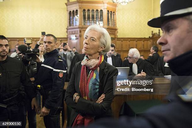 Christine Lagarde, managing director of the International Monetary Fund , center, listens whilst standing inside the courtroom on the opening day of...