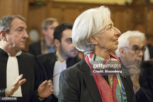 Christine Lagarde, managing director of the International Monetary Fund , stands inside the courtroom and next to members of her legal team on the...