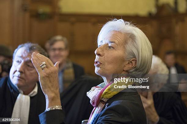 Christine Lagarde, managing director of the International Monetary Fund , center, gestures whilst speaking inside the courtroom and next to members...