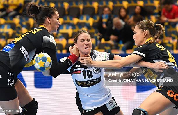 Spain's Elizabet Chavez and Judith Sans try to stop Germany's Anna Loerper as she prepares to throw the ball during the Women's European Handball...
