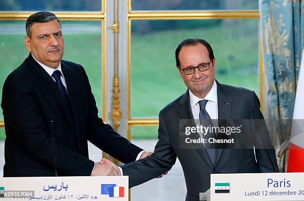 Riad Hijab, chief coordinator of the Syrian opposition's High Negotiations Committee , shakes hand with French President Francois Hollande after a...