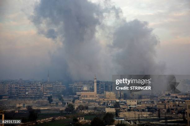 Smoke billows from the former rebel-held district of Bustan al-Qasr in Aleppo, on December 12 during an operation by Syrian government forces to...