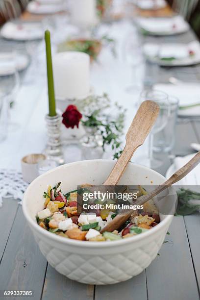 a bowl of salad on a table in a garden. - salad server stock pictures, royalty-free photos & images