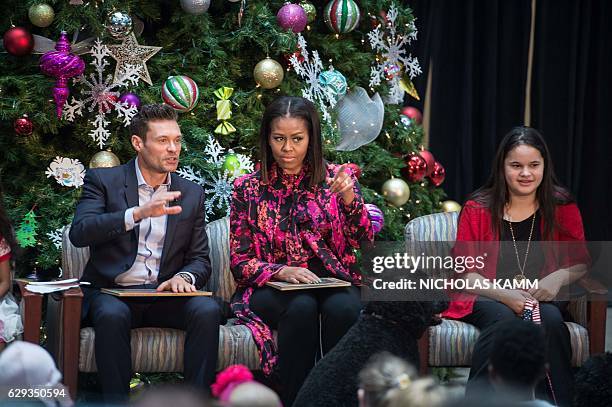 First Lady Michelle Obama and television personality Ryan Seacrest prepare to read "Twas The Night Before Christmas" to children at the Children's...