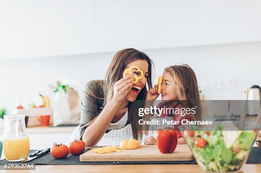 Mother and daughter having fun with the vegetables Mother and daughter having fun with the vegetables
