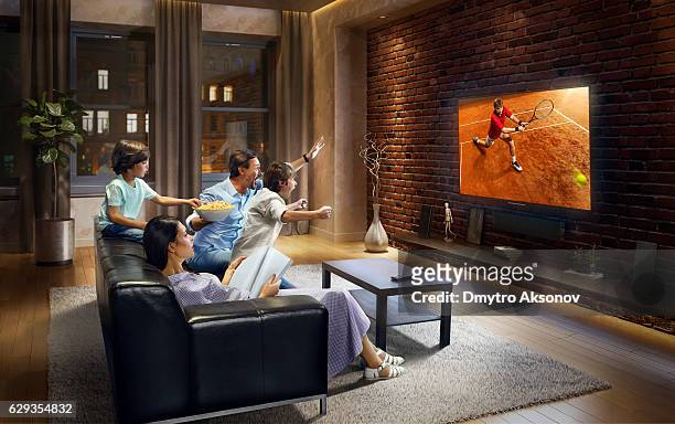 familia con niños, aclamando y mira un partido de tenis en el televisor - familia viendo television fotografías e imágenes de stock