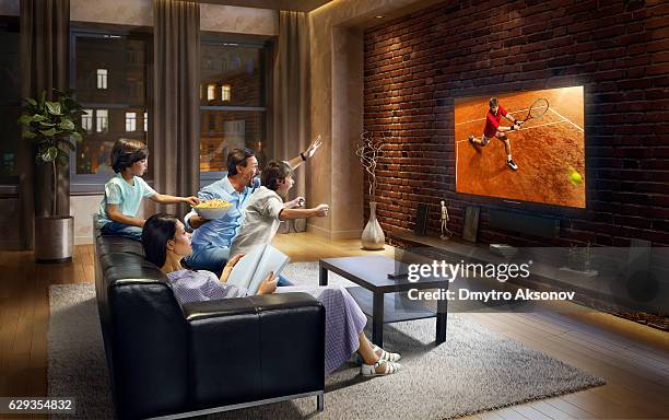 family with children cheering and watching tennis game on tv - tv family stockfoto's en -beelden