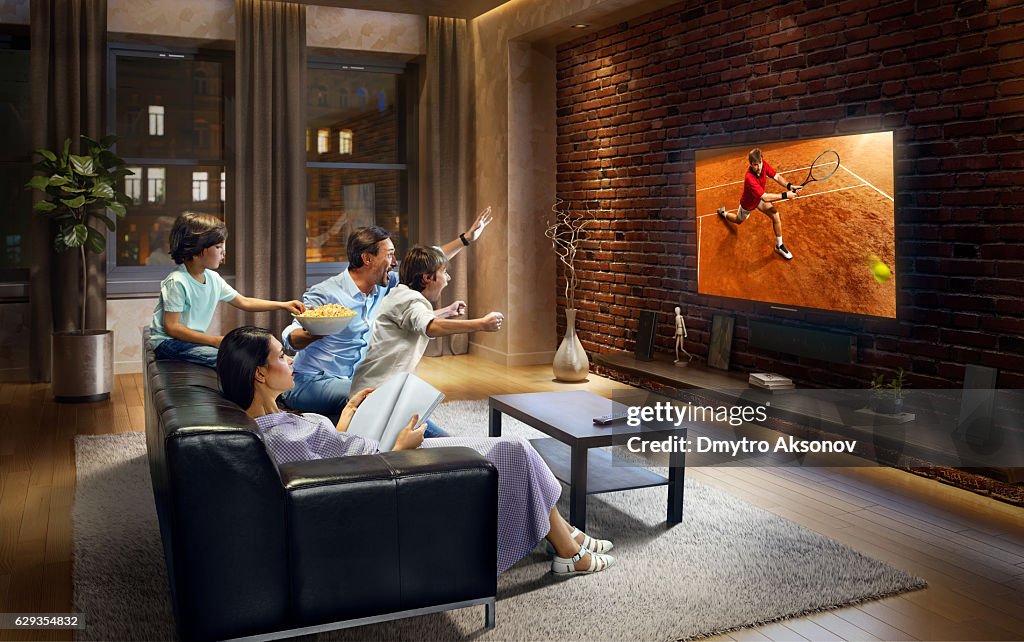 Family with children cheering and watching Tennis game on TV
