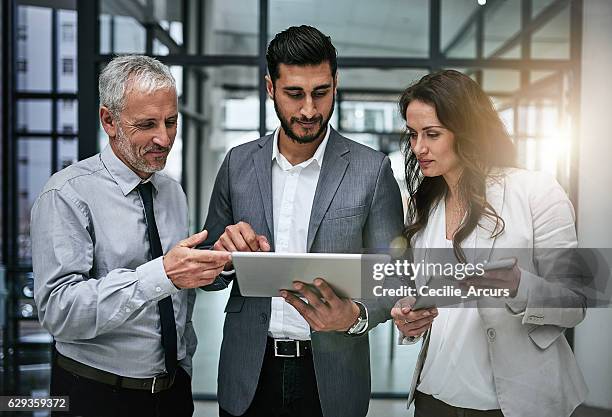 tracking business concerns as a team - mature business woman digital tablet corporate professional stockfoto's en -beelden