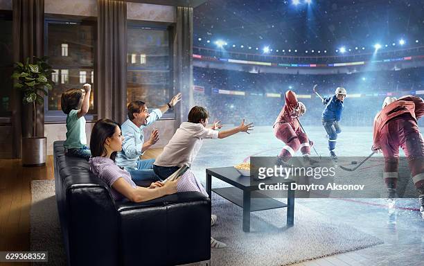 family with children watching ice hockey game on tv - ice hockey stockfoto's en -beelden