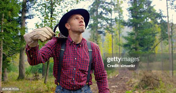 mann hält kettensäge und schaut nach oben - hosenträger stock-fotos und bilder