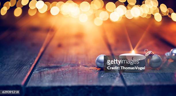 christmas candle and ornaments on  table - defocused blue wood - tea light stock pictures, royalty-free photos & images