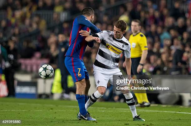 Thorgan Hazard of Borussia Moenchengladbach and Arda Turan of FC Barcelona battle for the ball during the UEFA Champions League match between FC...