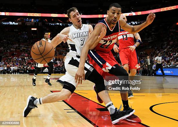 Goran Dragic of the Miami Heat has the ball knocked loose by Otto Porter Jr. #22 of the Washington Wizards during the first half of the game at...