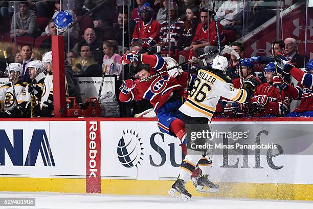 Kevan Miller of the Boston Bruins checks Alexei Emelin of the Montreal Canadiens during the NHL game at the Bell Centre on December 12, 2016 in...