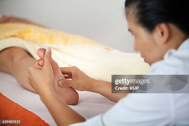 Naturopaths practice in France. Foot reflexology session.