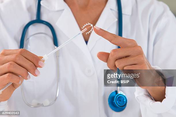 Doctor holding a copper IUD.