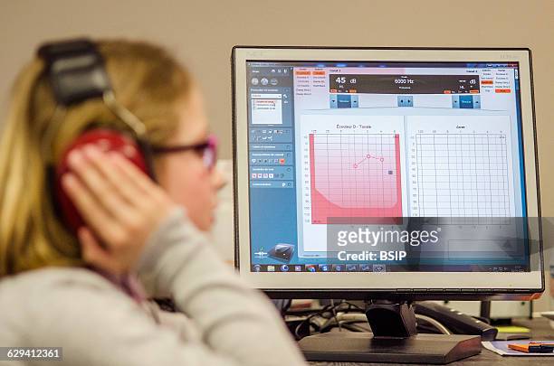 Reportage in a hearing care professional practice. Calibrating the hearing aid.