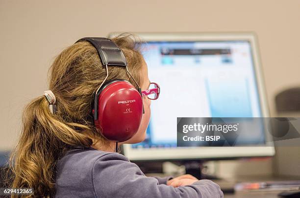 Reportage in a hearing care professional practice. Calibrating the hearing aid.