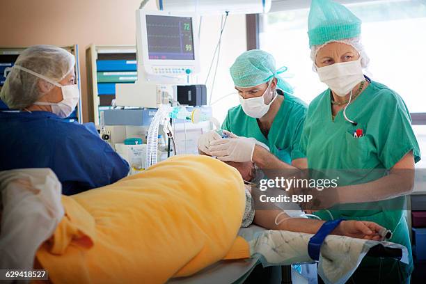 Orthopedic surgery, Léman hospital, Thonon, France. Operating theatre. The anaesthetist and anaesthetic nurse administer the general anaesthetic.