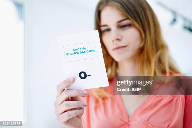 Woman holding her blood group card.