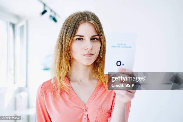 Woman holding her blood group card.