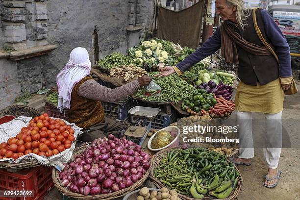Customer pays for vegetables at a stall in Varanasi, Uttar Pradesh, India, on Friday, Dec. 9, 2016. India is scheduled to release Consumer Price...