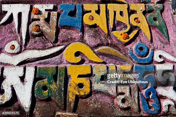 India. Bihar. Bodhgaya. Mani wall. Decorated with marigold flowers. In the grounds of the Mahabodhi Temple.