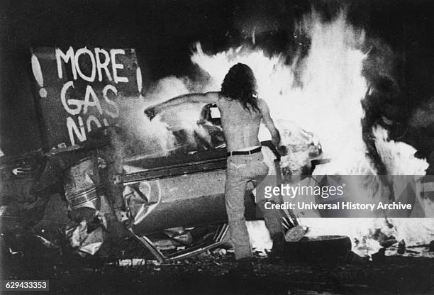 Gas Shortage Demonstrator in Front of Burning Car During Riot at Night, Levittown, Pennsylvania, USA, 1979.