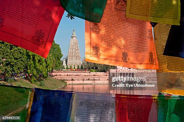 India. Bihar. Bodhgaya. Mahabodhi Temple framed by colourful Buddhist prayer flags.