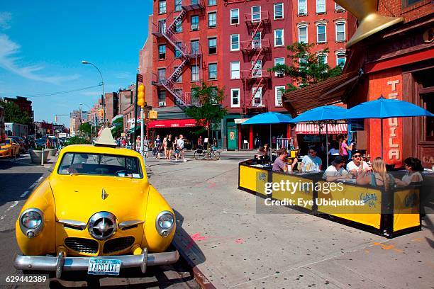 New York State. New York City. Manhattan. Greenwich village. Yellow Studebaker car parked outside the Caliente Cab Co Bar on the corner of Bleecker...