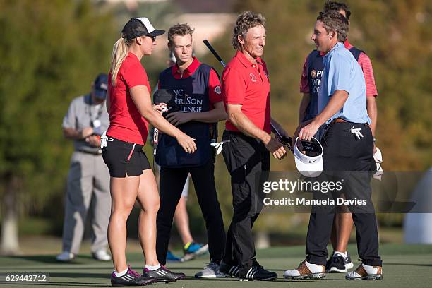 Christina, Jason and Bernhard Langer of Germany talk with Tucker Wadkins on the 18th green after the first round of the PNC Father/Son Challenge at...