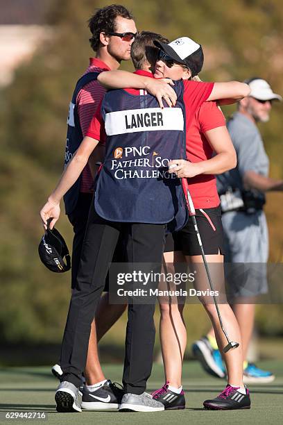 Jason and Christina Langer of Germany hug on the 18th green after the first round of the PNC Father/Son Challenge at The Ritz-Carlton Golf Club on...