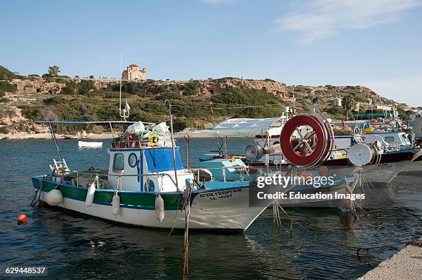 Church of St George overlooks the fishing boats at Agios Georgios harbor Cyprus.
