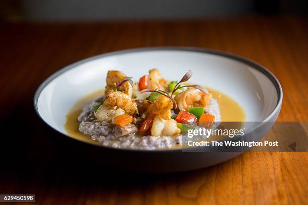 Ruben Garcia prepares shrimp and grits at Fish by Jose Andres in the MGM Casino on Oxon Hill, Maryland on December 10, 2016