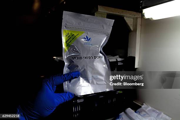 An employee holds a prescription package containing medical cannabis during packing at a plant operated by Breath of Life , in Kfar Pines, Israel, on...