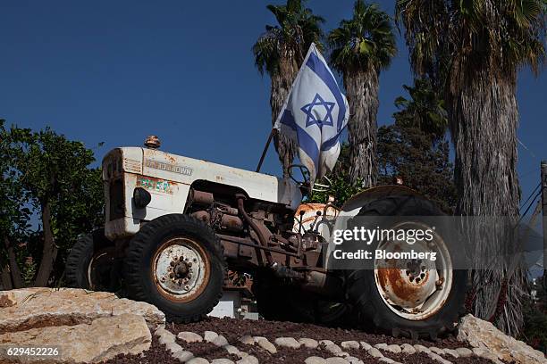 An Israeli national flag sits on a monument celebrating Israel's landmark traditional agriculture at the entrance to the village of Kfar Pines,...