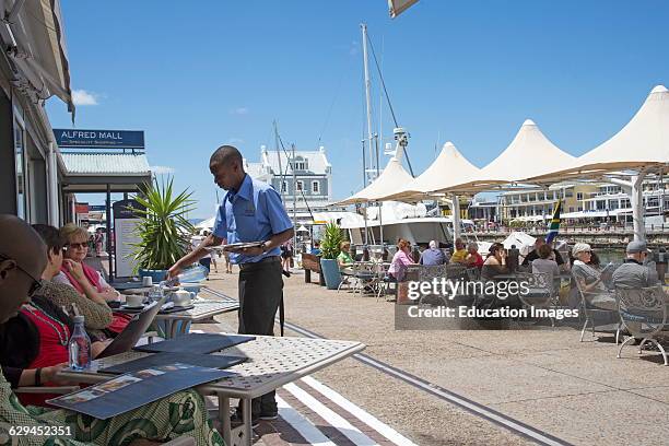 Tourists eating and drinking on the V&A Waterfront Cape Town South Africa.