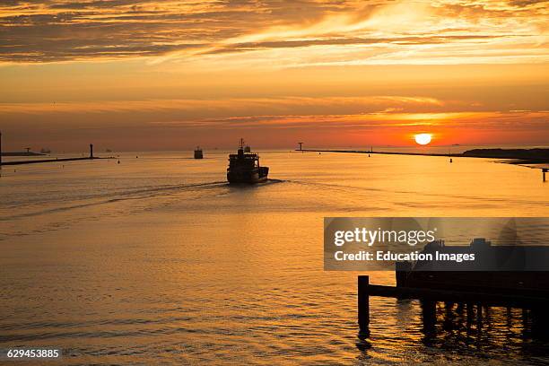 Sunset orange glow landscape clouds water, North Sea shipping, Port of Rotterdam, Hook of Holland, Netherlands.