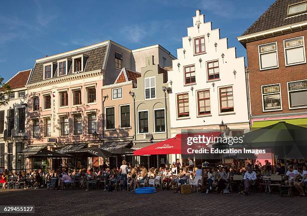 Historic buildings people sitting outside cafes central Utrecht, Netherlands.