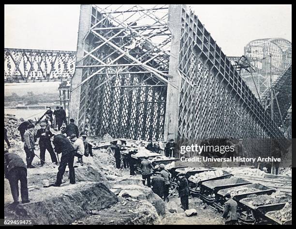 German soldiers stand guard as Polish prisoners of war are forced to mine rock. Taken in Warsaw, shortly after the invasion of Poland in 1939.