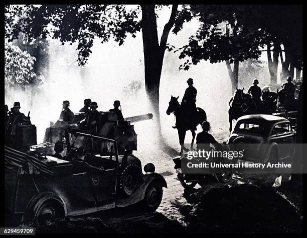 World War II, the German armed forces advance into Polish land along a dusty highway. Dated 1939.