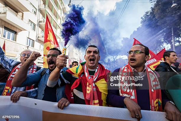 Thousands of people shout slogans and wave flags as they take to the streets to protest Prime Minister Matteo Renzi's government politics and to say...