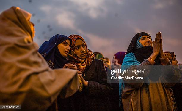 . Kashmiri Muslim women devotees look towards a cleric displaying the holy relic believed to be the whisker from the beard of the Prophet Mohammed,...