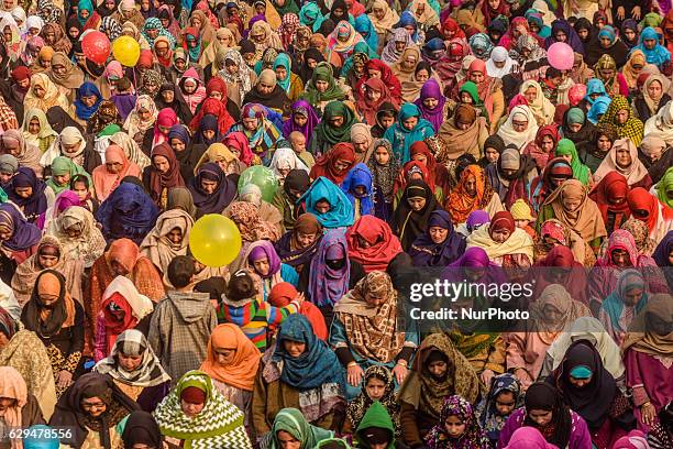 . Kashmiri Muslim women devotees look towards a cleric displaying the holy relic believed to be the whisker from the beard of the Prophet Mohammed,...