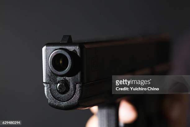 holding a gun on black background - trigger bildbanksfoton och bilder