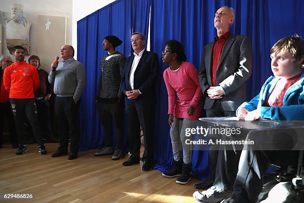 Uli Hoeness , President of FC Bayern Muenchen talks as he with his players Xabi Alonso , Jerome Boateng and Karl Hopfner visit the School For...