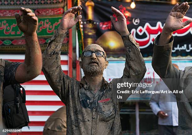 Iranian shiite muslim men praying after rubbing mud on their clothes during the Kharrah Mali ritual to mark the Ashura ceremony, Lorestan Province,...